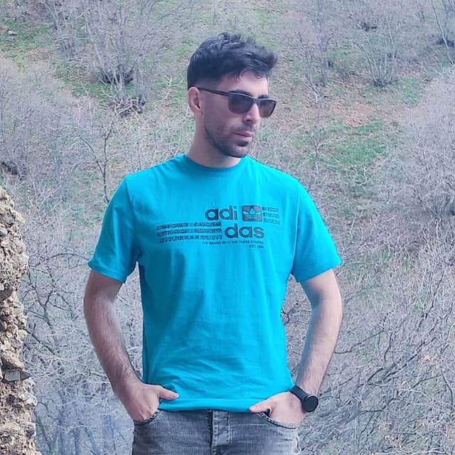 Hussein buiten in een turquoise shirt